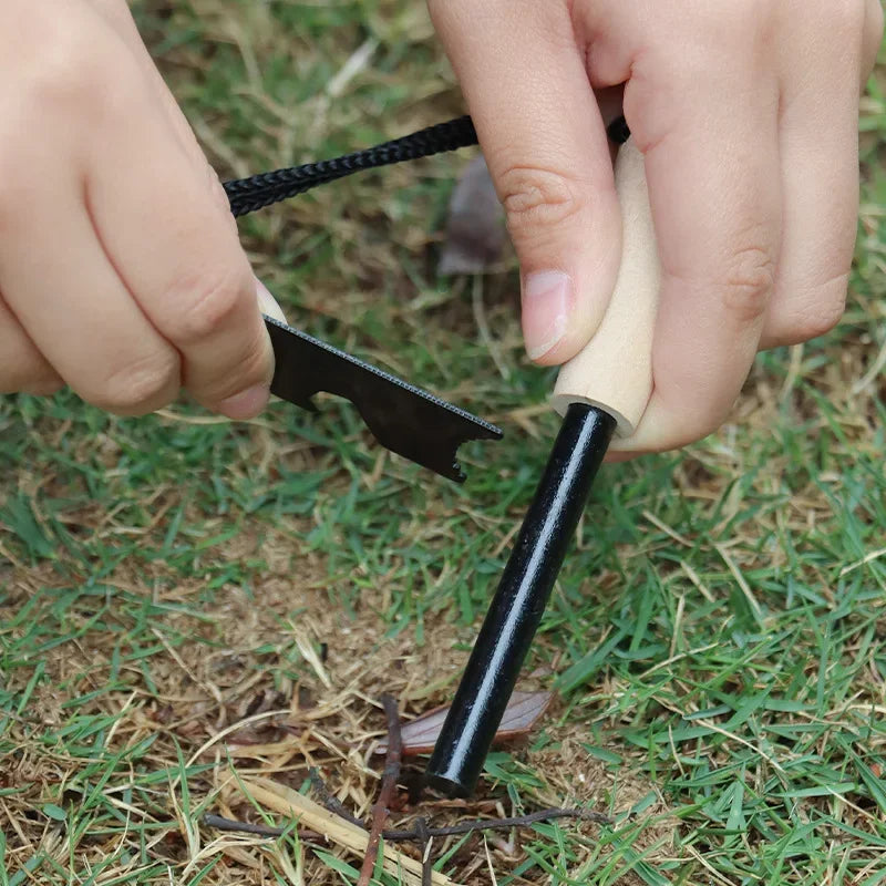 Person using a fire starter tool on grass